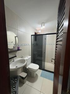 a bathroom with a toilet and a sink and a shower at Pousada Dra Lindalva in Maragogi