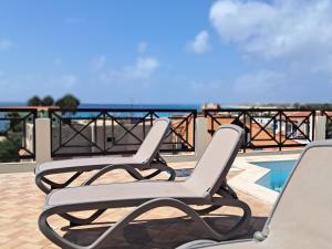 two lounge chairs sitting on a balcony overlooking the ocean at Patio Antigo 218 in Santa Maria