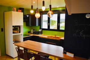 eine Küche mit einem Holztisch und grünen Wänden in der Unterkunft L'AQUARELLE - Escapade normande pour 6 pers in Grugny