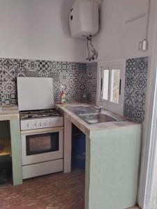 a small kitchen with a stove and a sink at Casa Edelmira Apartment in Vallehermoso