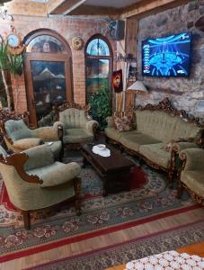 uma sala de estar com sofás e uma TV de tela plana em Etno kuca Petrovic em Štrpce