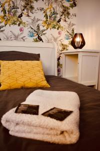 ein Schlafzimmer mit einem Bett mit einem weißen Handtuch darauf in der Unterkunft L'AQUARELLE - Escapade normande pour 6 pers in Grugny