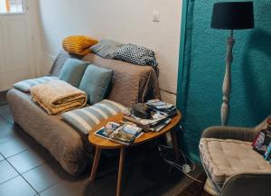 a living room with a couch and a table at Maison de Pêcheur La Gorge Bleue in Saint-Valéry-sur-Somme