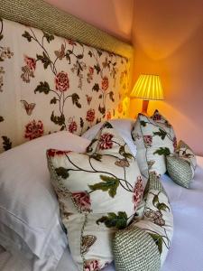 a bedroom with a bed with pillows and a floral wallpaper at The Seagrave Arms in Weston Subedge