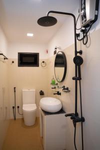 a bathroom with a toilet and a mirror and a camera at Cinnamon Wave Villa - Thalaramba, Mirissa in Matara
