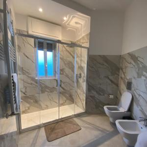 a bathroom with a shower and two toilets at Sunset Home in Bari +7 photos