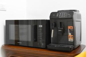 a microwave sitting on top of a wooden shelf at Sunset Home in Bari