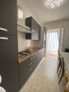 a kitchen with gray cabinets and a stove top oven at Sunset Home in Bari