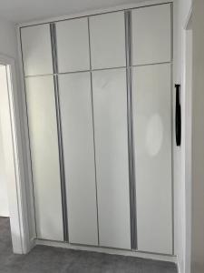 a large closet with white doors in a room at Apto Riviera Piscina Aquecida in Bertioga +44 photos