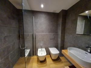 a bathroom with a toilet and a sink and a shower at Appartamento Viola in Santa Caterina Valfurva