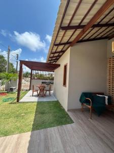 a patio with a table and chairs and a roof at Casamares Ipioca Beach Hibiscus Maceió in Maceió