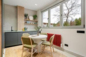 une cuisine avec une table, des chaises et des fenêtres dans l'établissement 139 Boutique Stay, à Vallecas