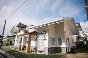 a white house with a large front door at Casa de Amor Modern Comfort across the pool in Dauis