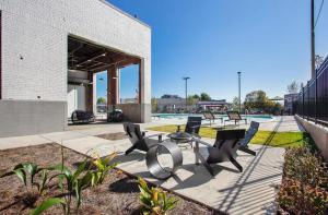 eine Gruppe von Stühlen und Tischen neben einem Pool in der Unterkunft Comfortable Atlanta Stay Near Mercedes-Benz Stadium in Atlanta