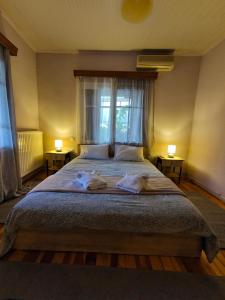 a bedroom with a large bed with two towels on it at Citadel's Tranquility Ioannina in Ioannina +19 photos