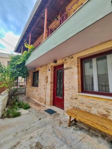 a building with a red door and a wooden bench at Citadel's Tranquility Ioannina in Ioannina