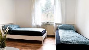 a bedroom with two beds and a window at Haus für 8 Personen, 4 Zimmer in Wenzendorf