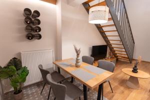 a dining room with a table and chairs and a staircase at Ground Living in Volos