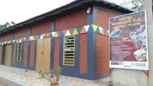 a small building with a sign in front of it at Monique CZ Abomey Plage in Abomey
