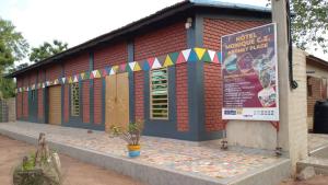 a building with a sign in front of it at Monique CZ Abomey Plage in Abomey