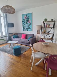 a living room with a couch and a table at Hyper centre lumineux avec balcon in Tours