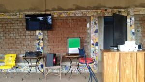 a table and chairs with a computer on a wall at Monique CZ Abomey Plage in Abomey