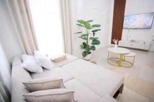 a living room with a white couch and a table at Casa de Amor Modern Comfort across the pool in Dauis