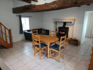 ein Tisch und Stühle in einem Wohnzimmer mit Kamin in der Unterkunft Chez Elise et Margot in Saint-Cosme-en-Vairais + 5 Fotos