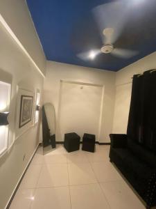 ein Wohnzimmer mit einem Sofa und einer Decke in der Unterkunft Beach Side Studio Apartment in Karatschi