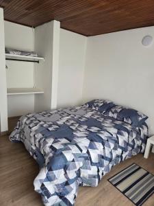 Un dormitorio con una cama con un edredón azul y blanco. en Los Muiscas Tunja, en Tunja