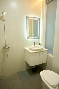 a bathroom with a sink and a toilet and a mirror at Khách sạn Thảo An in Phước Hậu (1)