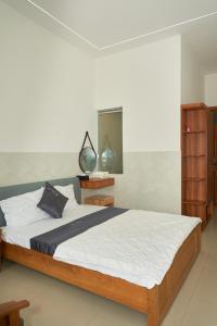 a bedroom with a large bed and a mirror at Khách sạn Thảo An in Phước Hậu (1) +11 photos