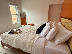 a bedroom with a bed with white sheets and pillows at Short North Convention King Bed Free Parking! in Columbus
