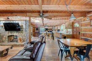 a living room with a table and a stone fireplace at Hidden Creek Cabin in Fleetwood