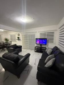 a living room with couches and a flat screen tv at Playa Dorada Mountainview Villa in San Felipe de Puerto Plata
