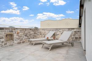 two chairs on a patio with a stone wall at Villa Istria Mar in Pazin