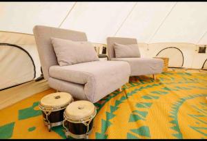 a living room with a couch and drums in a tent at Piebald Mountain Pet Friendly Tents, Petersburg, New York in Pownal