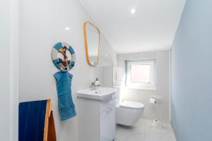 a white bathroom with a toilet and a sink at Villa Cosy in Trogir