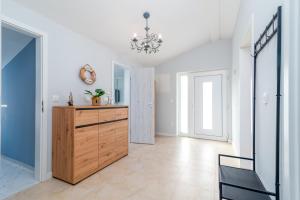 a hallway with a dresser and a chandelier at Villa Cosy in Trogir