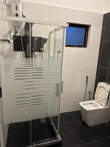 a bathroom with a glass shower and a toilet at Knuckles View Hotel in Palapatwela