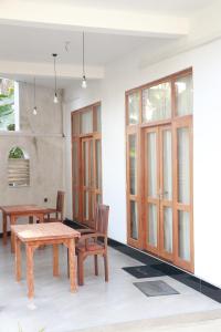 a dining room with wooden tables and chairs at Pabalu House in Ahangama