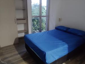 a bedroom with a blue bed and a window at Casa de Verano in Santa Fe de Antioquia +9 photos