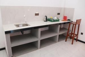 a kitchen counter with a sink and a wooden chair at Pabalu House in Ahangama +2 photos