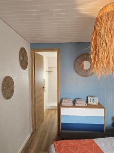 a room with a bed with a blue wall at Gîte "Hawaï", avec parking securisé in La Roche-sur-Yon +22 photos