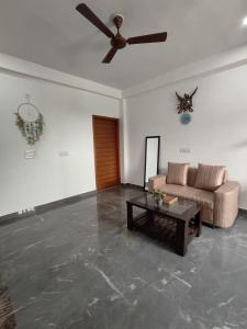 a living room with a couch and a ceiling fan at Srivastav Homestay in Noida