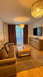 a living room with a couch and a tv at VENUS Studios at Coresi Mall in Braşov
