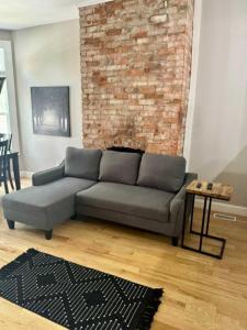 a living room with a couch and a brick wall at Highland Apartment in Columbus