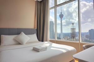 クアラルンプールにあるSky Suites KLCC By Tomのベッドと大きな窓があるホテルの部屋