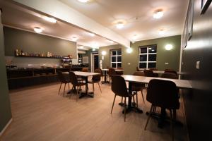 a restaurant with tables and chairs and a bar at Vik Tröll Hotel in Vík