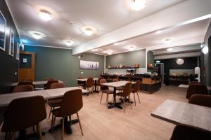 a waiting room with tables and chairs and a counter at Vik Tröll Hotel in Vík